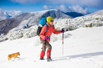 Girl with dog in winter mountains.