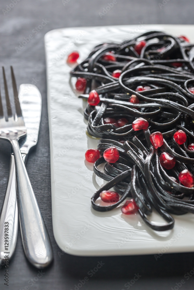 Sticker black pasta with pomegranate seeds