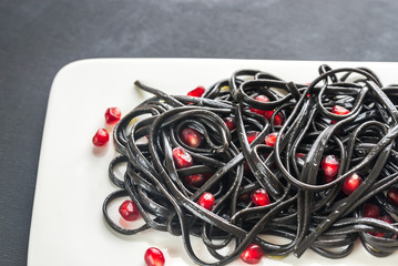 Black pasta with pomegranate seeds