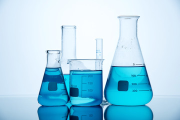 Different laboratory glassware with color liquid and with reflection