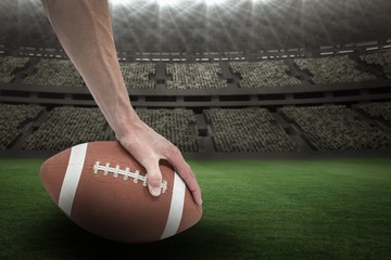 Composite image 3D of american football player placing the ball