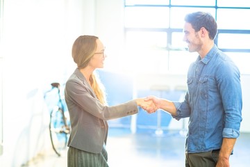 Businesswoman shaking hands with coworker