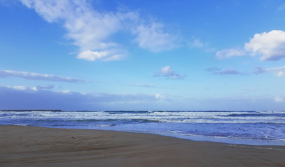 Fototapeta na wymiar Deserted beach near the blue sea
