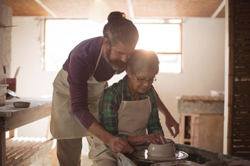 Male potter assisting female potter
