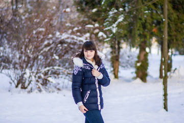 Pretty girl standing in a winter park