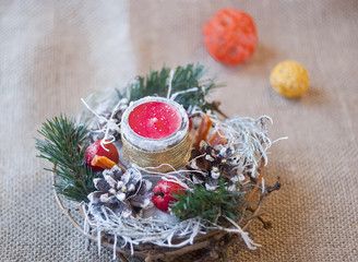 a wreath of fir branches with candles, cones and nuts