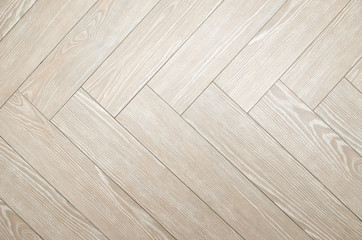 Beige floor tiles with look of parquet arranged in herringbone