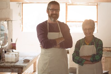 Portrait of male and female potter standing with arms crossed