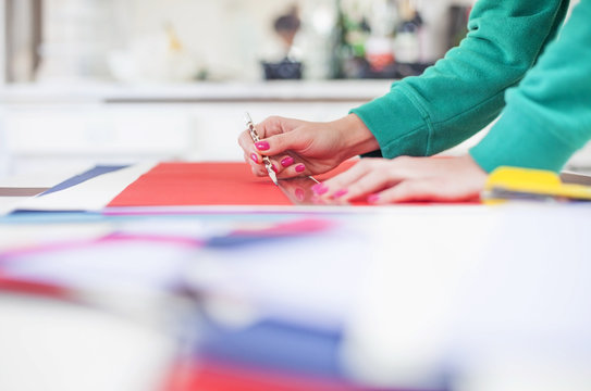 Young woman make scrapbook of the papers on the table using antique tools for cutting paper. Hand made photo album.Shallow depth of field