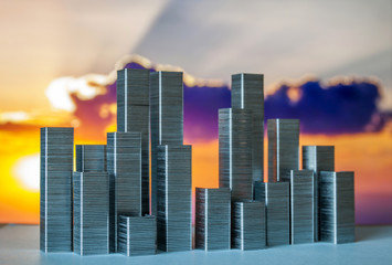 Staples arranged to form city skyline on a sunset background