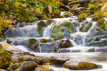 Fototapeta na wymiar Small Waterfall in park with beautifull smooth water. Little wat