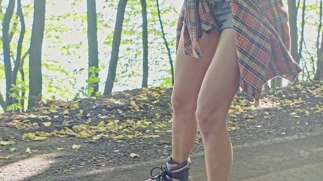 Happy young woman on roller skates in the summer park