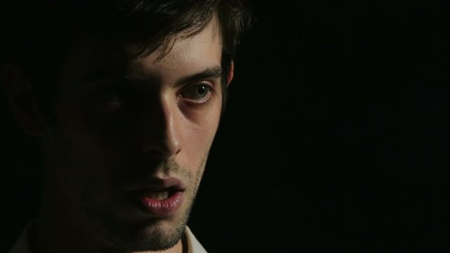 desperate young man on dark background: sad, sadness, smoking, loneliness
