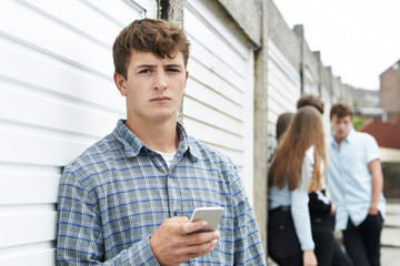 Teenage Boy Using Mobile Phone In Urban Setting