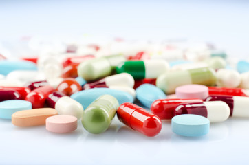 Pharmacy theme. Multicolored Isolated Pills and Capsules on the White Surface. Closeup