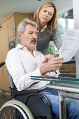 Fototapeta premium Couple With Husband In Wheelchair Reading Letter