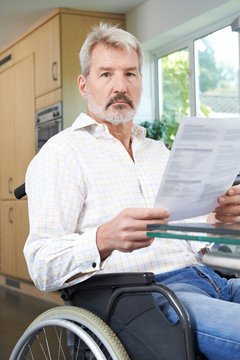 Frustrated Man In Wheelchair Reading Letter