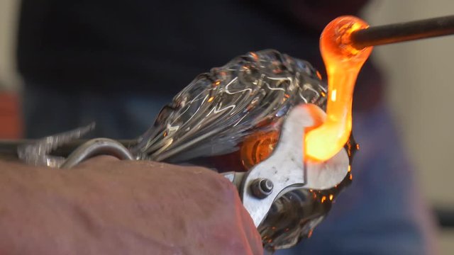 Man Puts Liguid Glass to the Bottom of Statuette Glassblower at Festival of High Temperatures People Show Their Skills Making Glass Decoration Lampworker