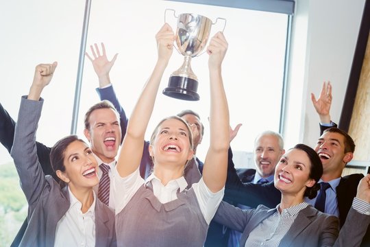 Winning Business Team With An Executive Holding Trophy