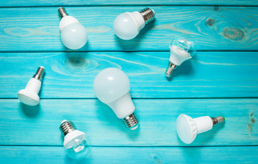 Set of different row LED bulbs on blue wood background.