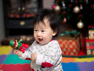 Teething baby girl with her christmas toy