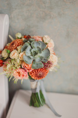 wedding bouquet of orange, beige and pink flowers with succulent © anna_gorbenko