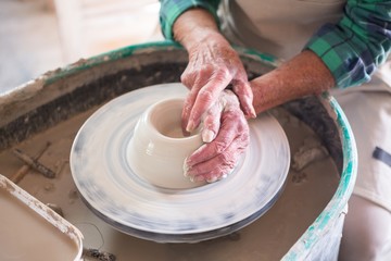 Mid section of potter making pot