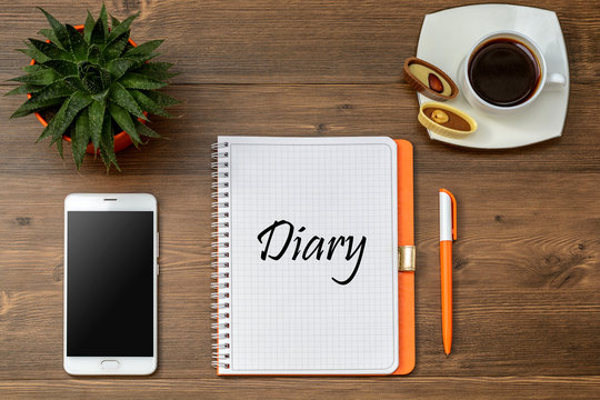 Business accessories on desktop: notebook, diary, fountain pen,