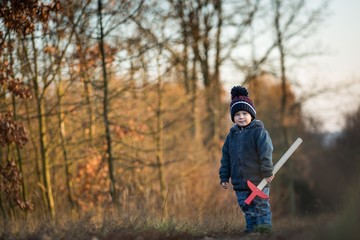 Young boy playing outdoor with wooden sword