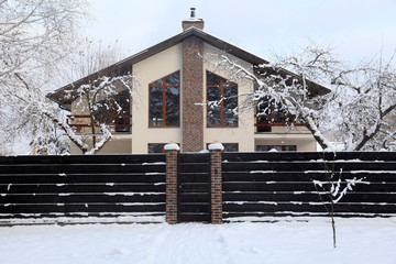 Front of suburban home under snow in winter - 129612877
