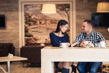 Fototapeta na wymiar Young couple talking in coffee shop