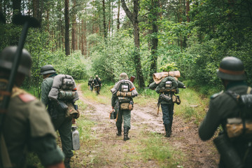 Fototapeta premium Unidentified Re-enactors Dressed As German Soldiers Marching Alo