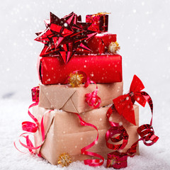 Christmas Gifts in Red and beige Boxes Tied with Festive Ribbons on a White Background in the...