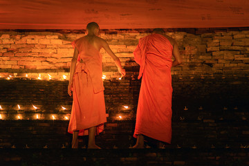 Buddhist monk hands holding candle cup in the dark ,Chiang mai , Thailand
