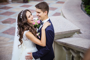 Happy young bride and groom going outdoors