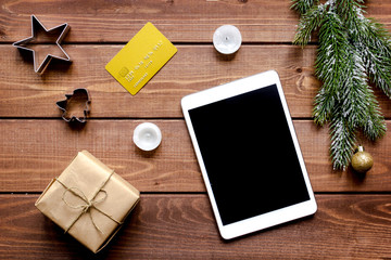 online shopping christmas with e-tablet wooden background top view