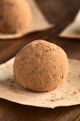 Hausgemachte Rumkugel mit Kakaopulver, fotografiert mit natürlichem Licht (Selektiver Fokus, Fokus auf die Vorderseite der Rumkugel)