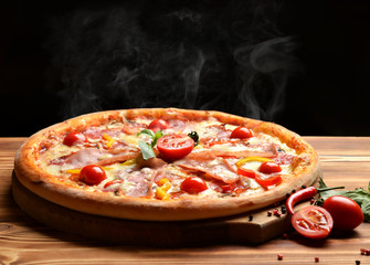 Hot big whole tasty pizza with melting cheese bacon tomatoes ham