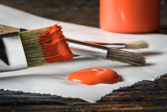 Artist's Paint Brushes with Red Orange Paint