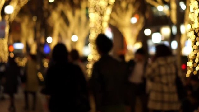 ライトアップされた街並みと歩道を歩く人々