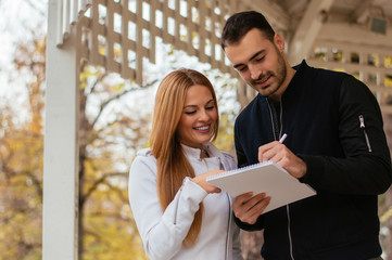 Business man and woman smiling and taking notes