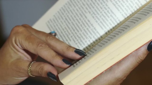 close up on hands of  woman reading a book