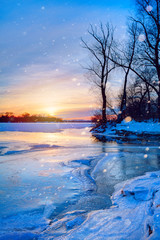 winter landscape panorama; sunset on the bank of a frozen river;