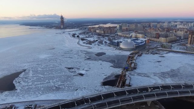 Aerial view of The third cable-stayed bridge, the bridge through a ship waterway, near the football Zenith Arena stadium dated for the FIFA World Cup in 2018, the snow, the frozen river Neva