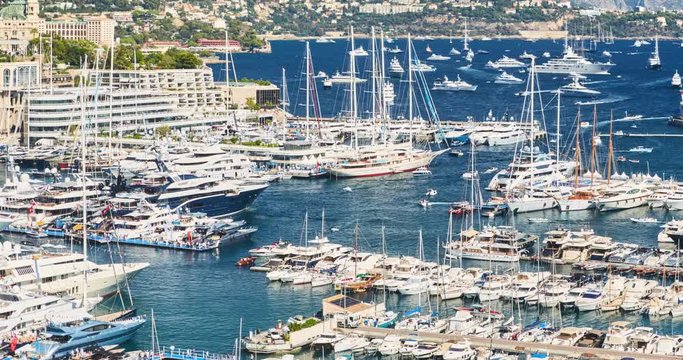 Timelapse of World Fair MYS Monaco Yacht Show, Port Hercules, luxury megayachts, big boat, sunny day, many shuttles, taxi boat, presentations, Journalists, zoom effect, boat traffic, Azur water,