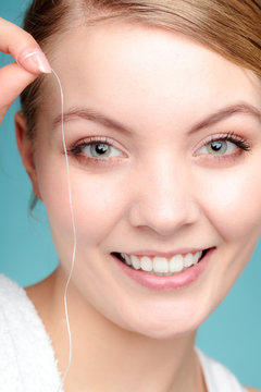 Smiling young woman hold dental floss.