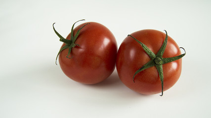 two red tomatoes on white background