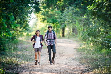Obraz premium Young couple walking with backpacks in forest. Adventure hikes,