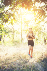 Young woman jogging on rural road in forest nature.