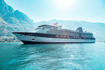 Fototapeta premium Cruise liner ship swimming at blue adriatic sea, mountains landscape